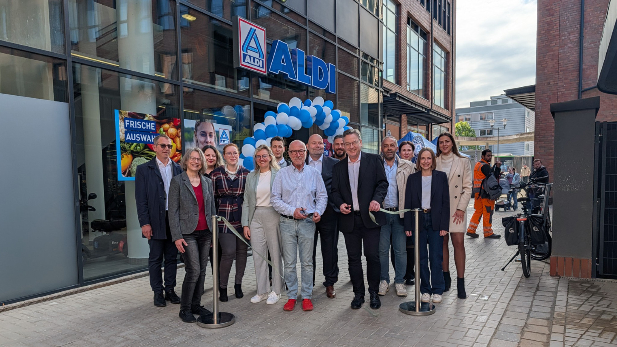 Die symbolische Banddurchtrennung durch Bürgermeister Fred Toplak (M.) zeigt allen: Die neue ALDI Nord-Filiale in den Hertener Höfen ist nun feierlich eröffnet. (Foto: Stadt Herten_Calina Herzog)